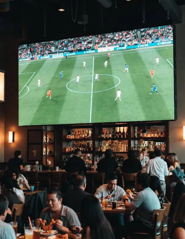 Bar con un televisor grande transmitiendo un partido